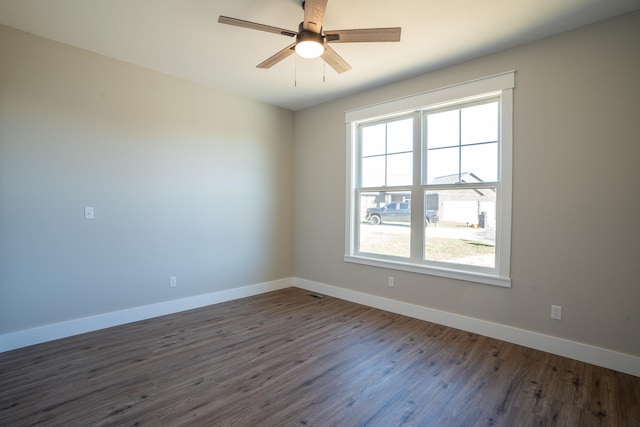 empty room with ceiling fan, dark hardwood / wood-style floors, and plenty of natural light