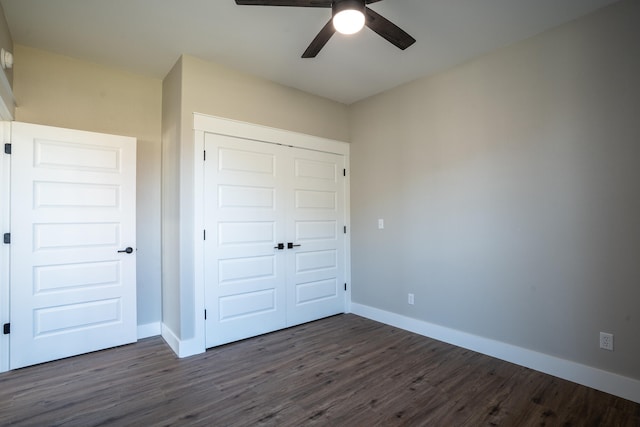 unfurnished bedroom with dark wood-type flooring, ceiling fan, and a closet