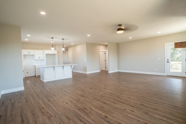 unfurnished living room with dark wood-type flooring and ceiling fan