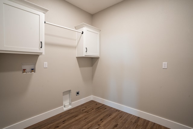 laundry area with dark hardwood / wood-style flooring, hookup for a washing machine, electric dryer hookup, and cabinets