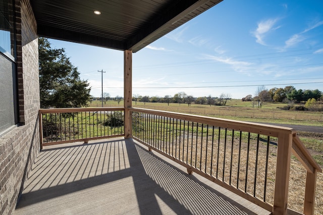 wooden deck with a porch and a rural view