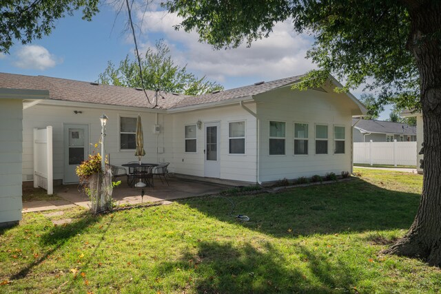 back of property with a patio and a lawn