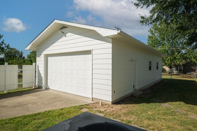 view of property exterior with a garage, an outdoor structure, and a lawn