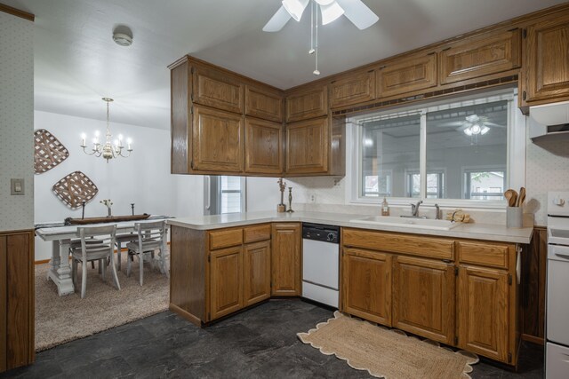 kitchen featuring sink, kitchen peninsula, pendant lighting, white appliances, and ceiling fan with notable chandelier