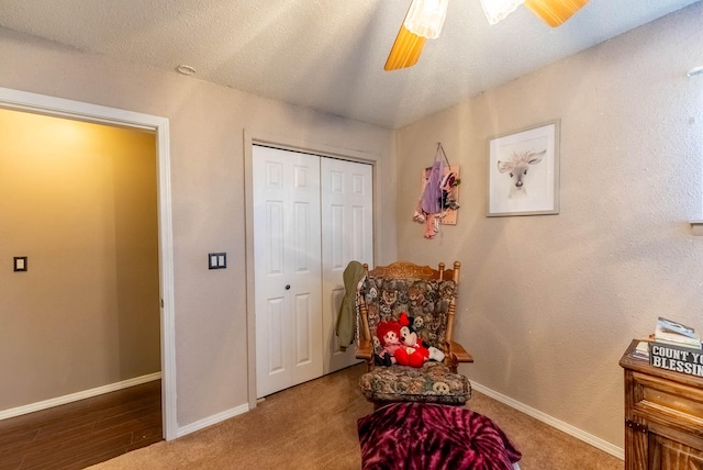 sitting room featuring a textured ceiling, ceiling fan, and carpet