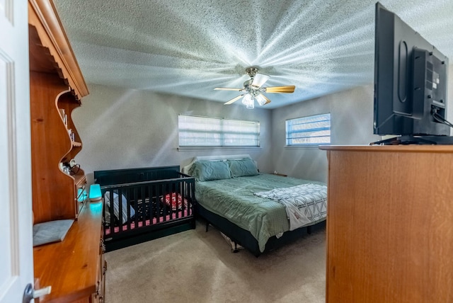 bedroom featuring ceiling fan, carpet floors, and a textured ceiling