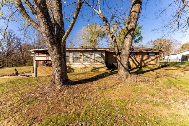 back of house featuring a yard and a wooden deck