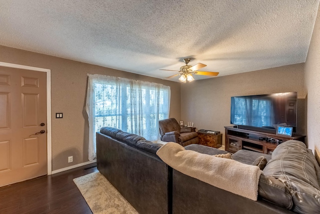 living room with a textured ceiling, dark hardwood / wood-style flooring, and ceiling fan