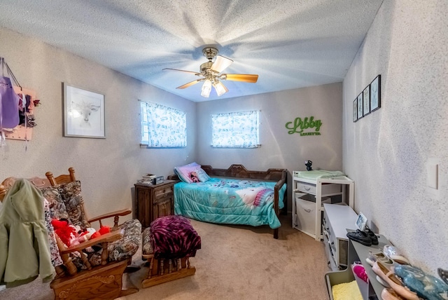 bedroom featuring ceiling fan, light carpet, and a textured ceiling