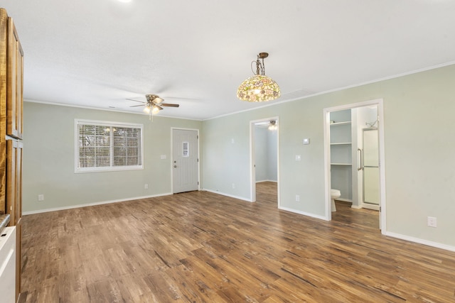 unfurnished living room featuring hardwood / wood-style floors, ceiling fan, and crown molding