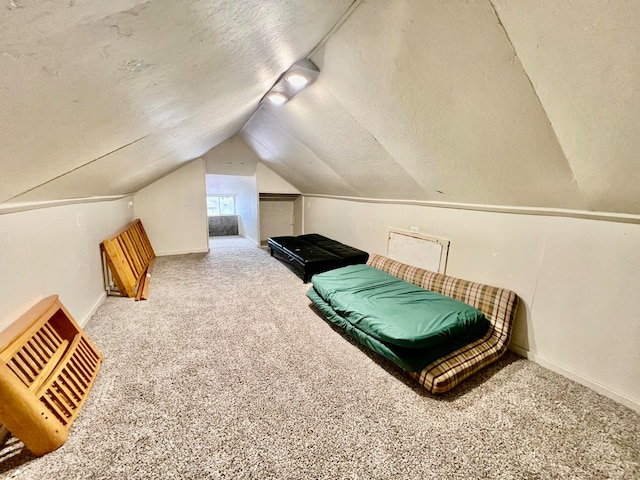 carpeted bedroom featuring a textured ceiling and vaulted ceiling