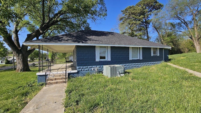 view of side of property featuring a lawn, a porch, and cooling unit