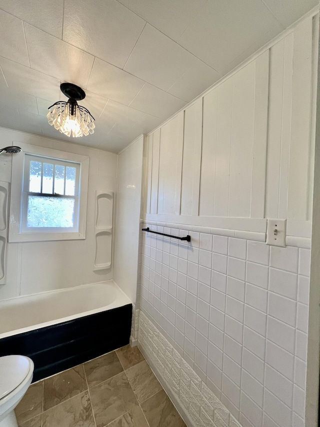 bathroom featuring toilet and bathing tub / shower combination