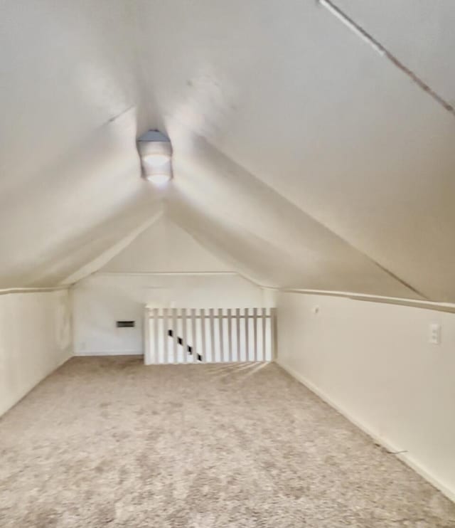 bonus room with lofted ceiling and carpet