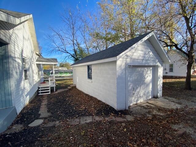 exterior space featuring a garage and an outbuilding