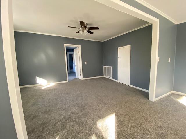 carpeted empty room with ceiling fan and crown molding