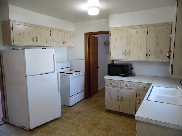 kitchen with white appliances, sink, and light brown cabinetry