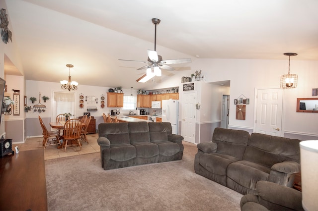 living room with ceiling fan with notable chandelier, light colored carpet, and lofted ceiling