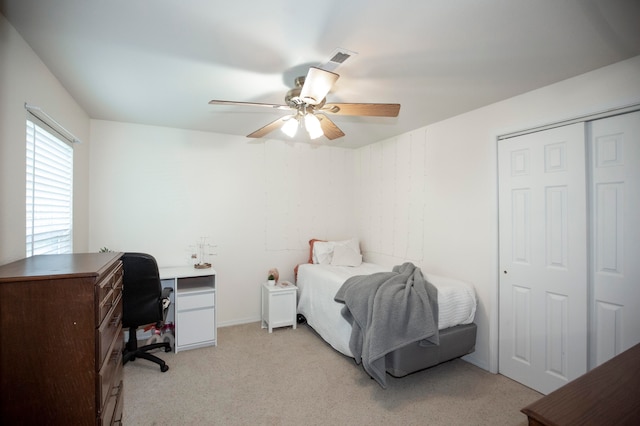 bedroom featuring ceiling fan, a closet, and light colored carpet