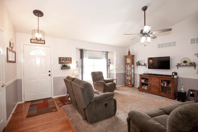 living room with ceiling fan, light hardwood / wood-style floors, and vaulted ceiling