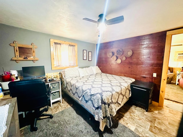 bedroom featuring a wall unit AC and ceiling fan