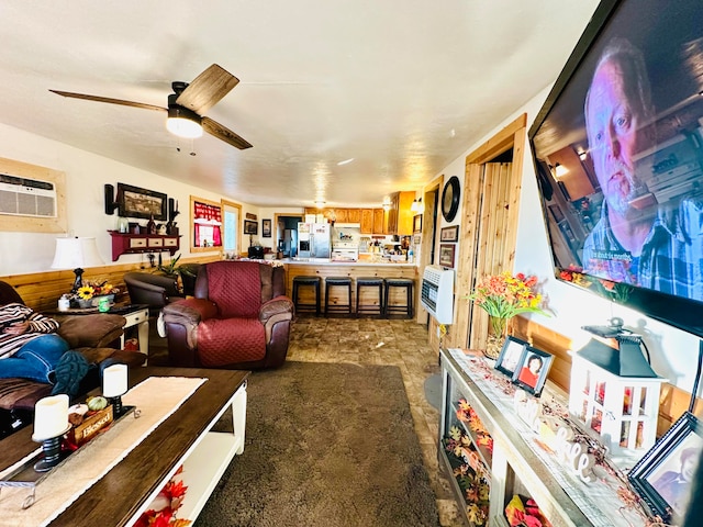 living room with heating unit, ceiling fan, and a wall mounted AC