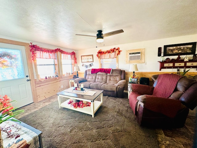 living room with a textured ceiling, an AC wall unit, and ceiling fan