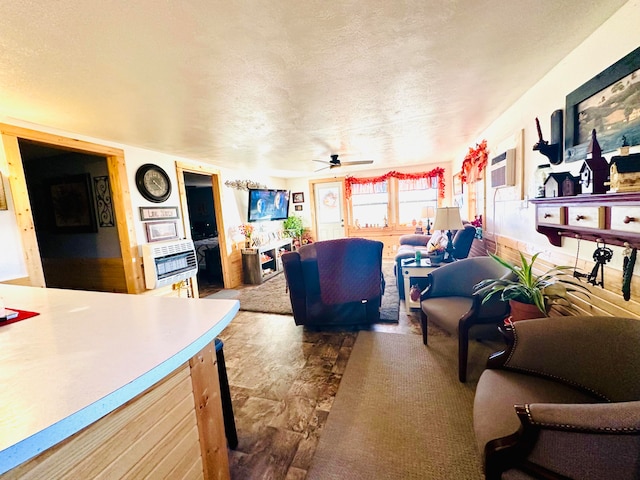 living room featuring ceiling fan, a textured ceiling, and heating unit