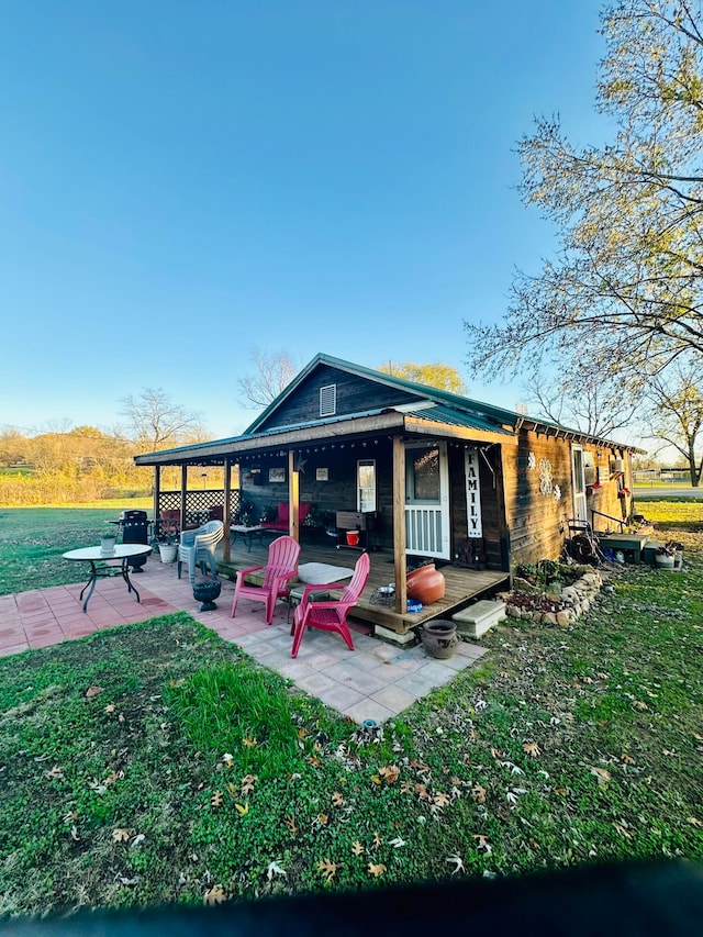 back of property featuring a lawn and a patio area