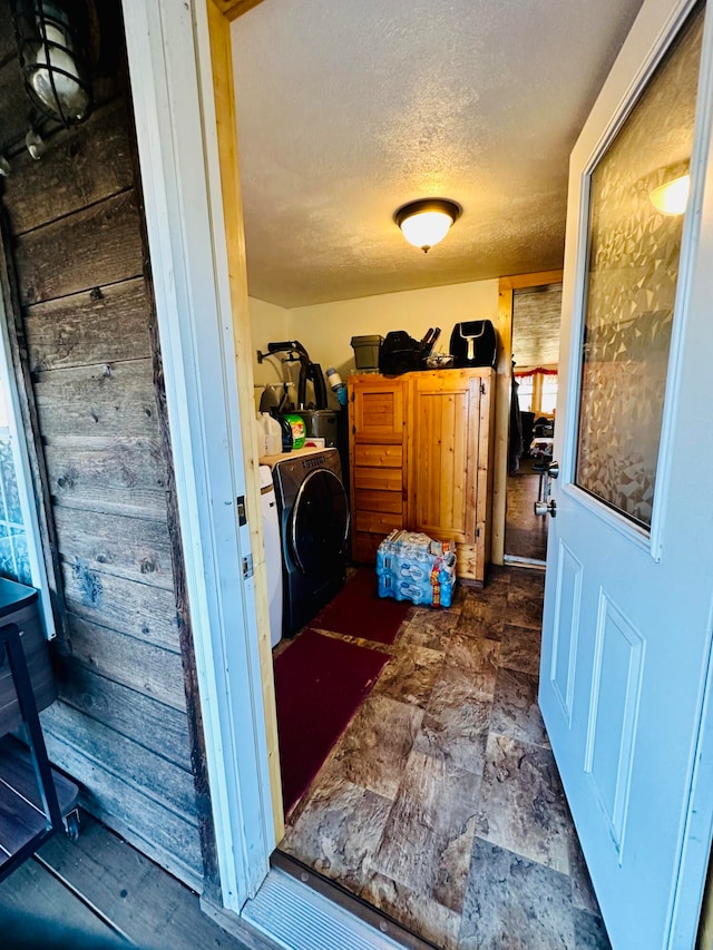 laundry area with a textured ceiling and washer / clothes dryer