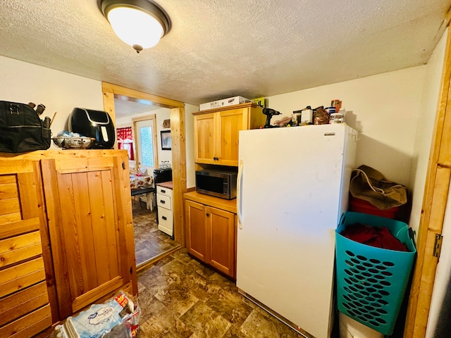 kitchen featuring a textured ceiling and white refrigerator