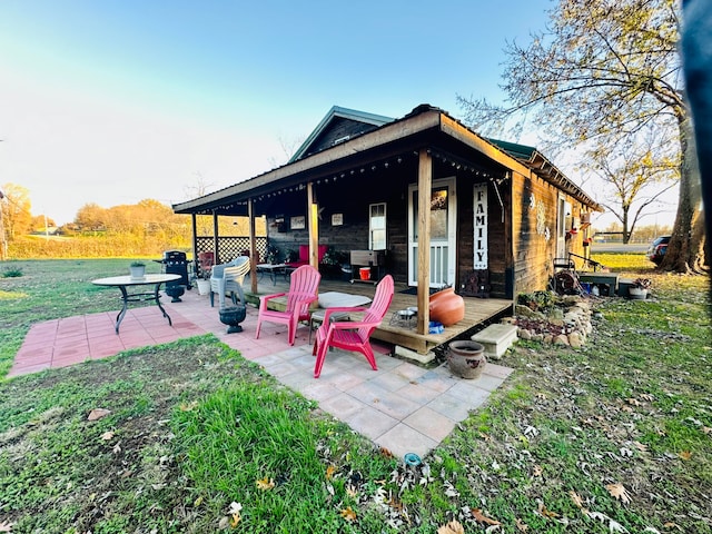 back of house featuring a lawn and a patio