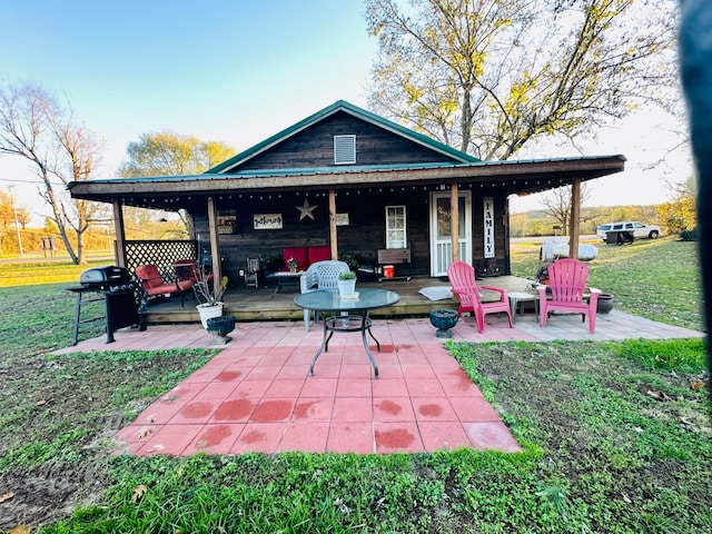 back of property with a lawn and a patio