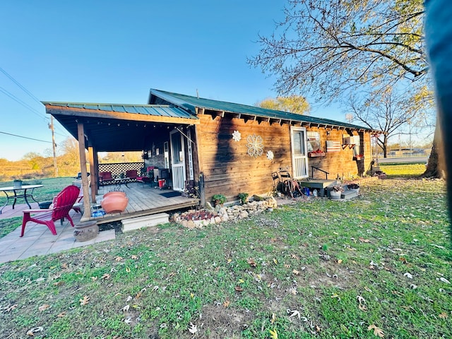 back of property featuring a lawn, a patio area, and a wooden deck