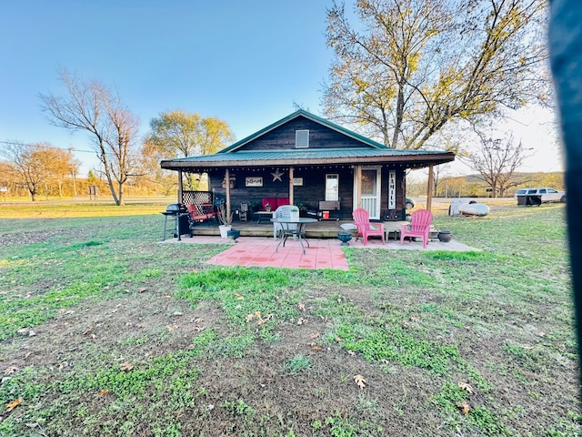 rear view of property with a lawn and a patio