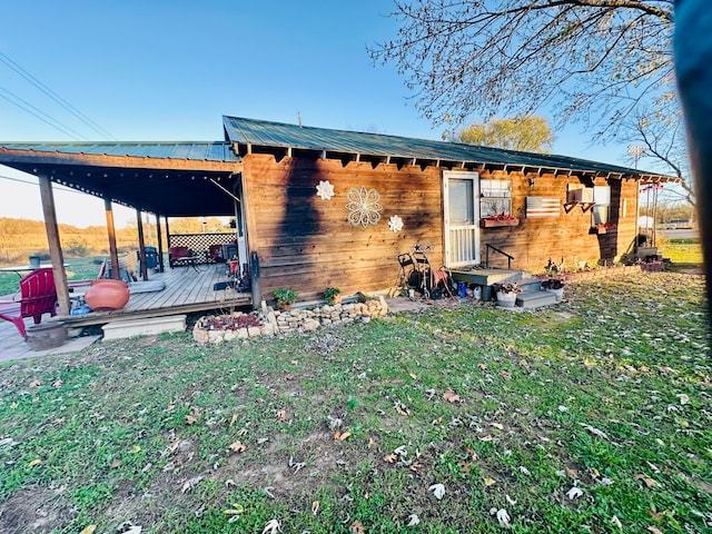 back of property with a deck and a yard