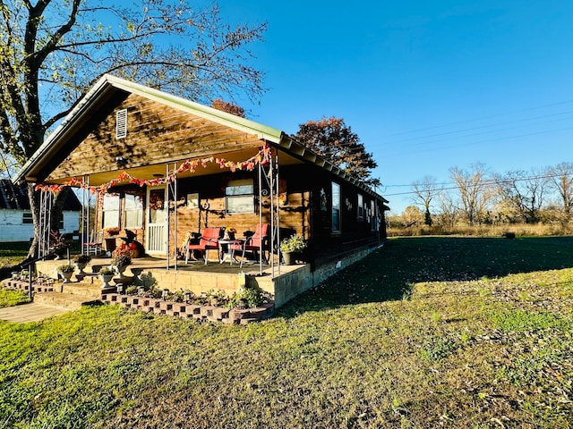 exterior space with covered porch and a yard