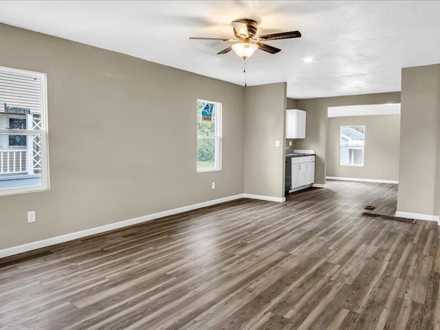 unfurnished living room with dark hardwood / wood-style floors and ceiling fan