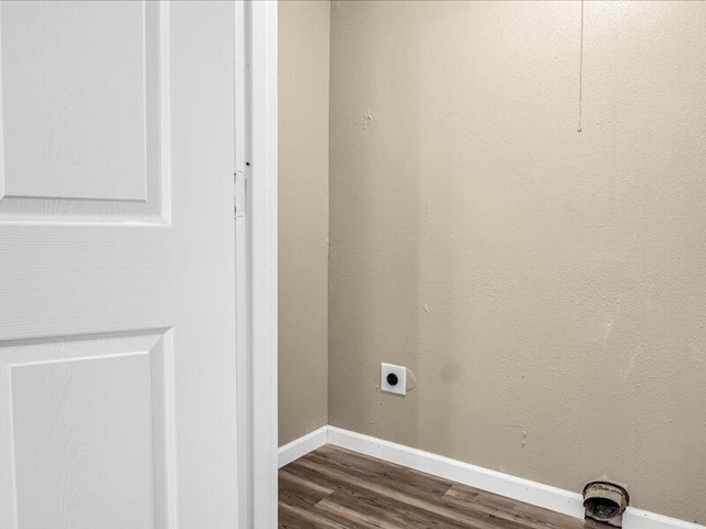 laundry room with electric dryer hookup and dark wood-type flooring