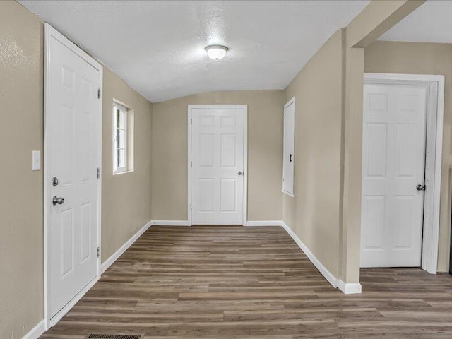 foyer entrance with dark hardwood / wood-style flooring and lofted ceiling