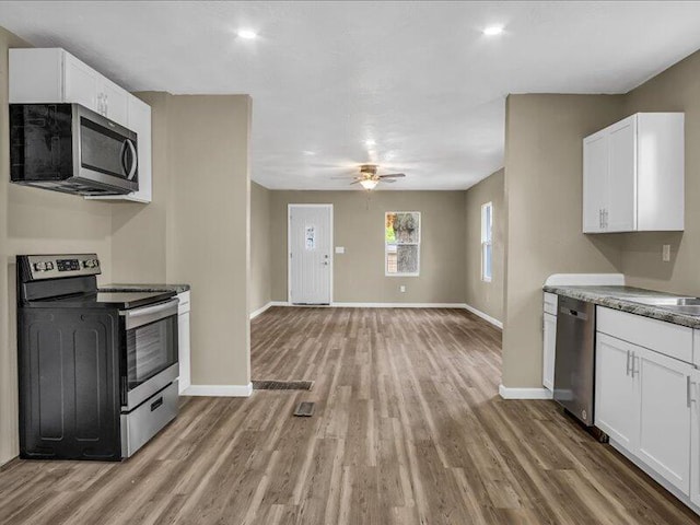 kitchen with appliances with stainless steel finishes, light hardwood / wood-style flooring, and white cabinetry