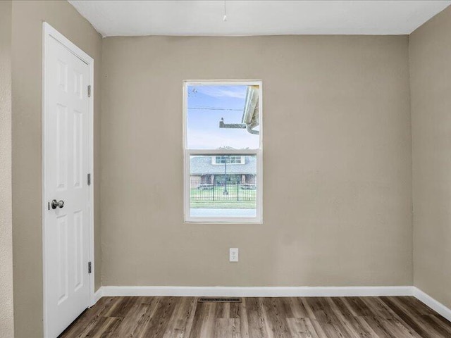 spare room with dark wood-type flooring