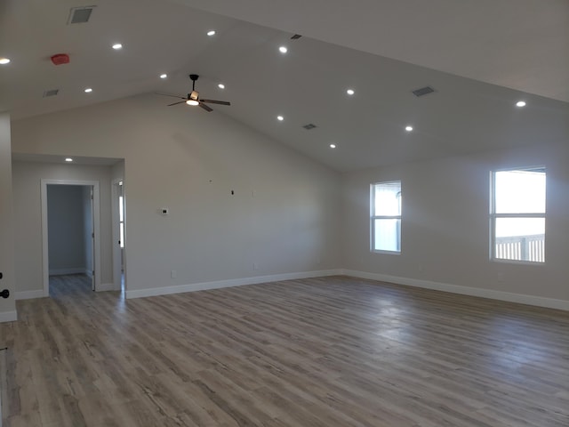 unfurnished room with ceiling fan, high vaulted ceiling, and light wood-type flooring