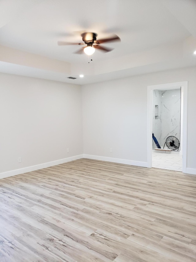 spare room with ceiling fan and light wood-type flooring