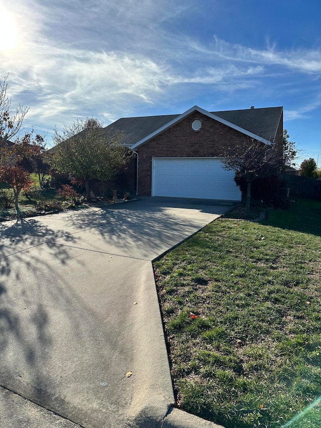 ranch-style home with a garage and a front yard