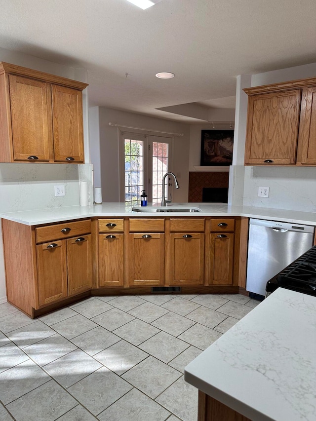 kitchen with sink, french doors, stainless steel dishwasher, kitchen peninsula, and light tile patterned flooring