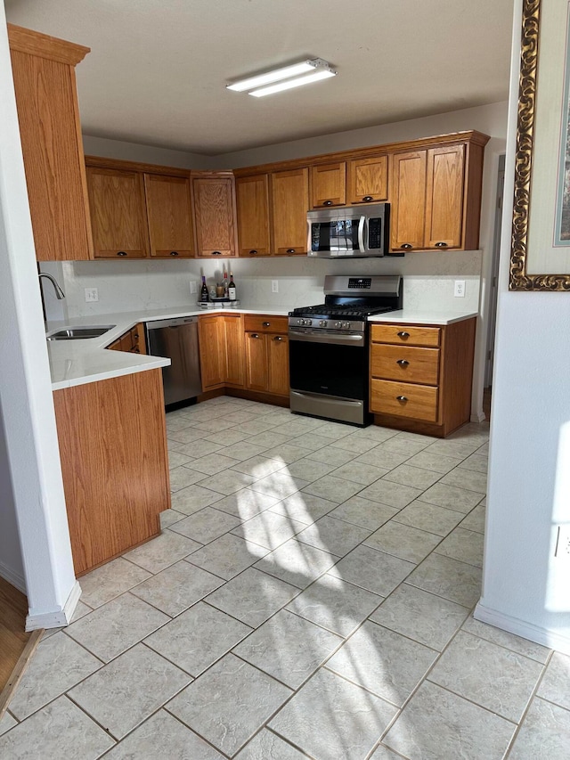 kitchen with appliances with stainless steel finishes, light tile patterned floors, and sink