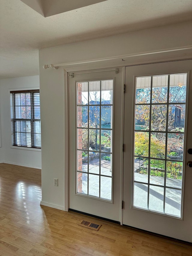 doorway featuring french doors and light hardwood / wood-style flooring