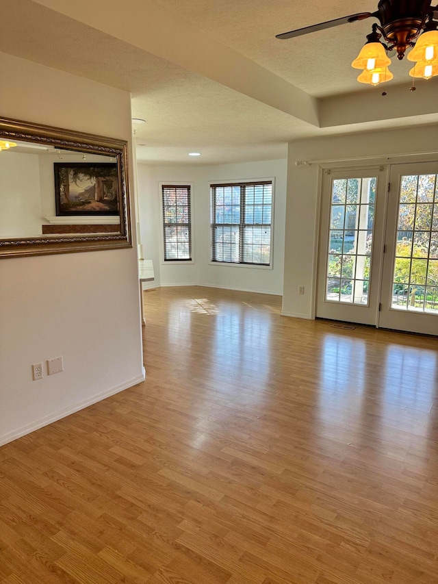 unfurnished room featuring ceiling fan, a textured ceiling, and light hardwood / wood-style flooring