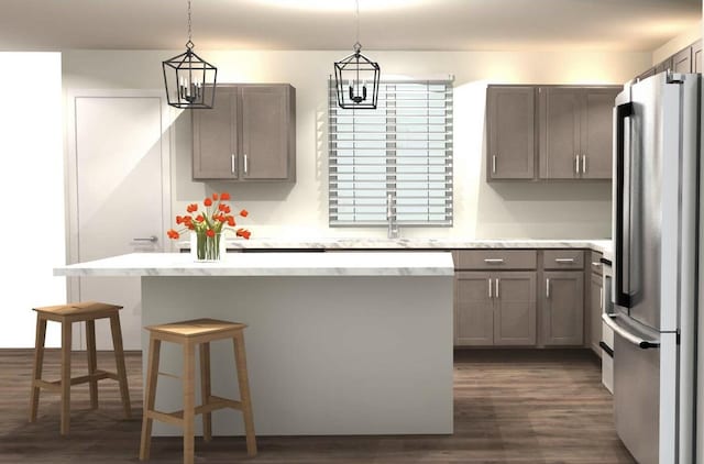 kitchen featuring hanging light fixtures, dark hardwood / wood-style floors, stainless steel fridge, a kitchen bar, and a kitchen island